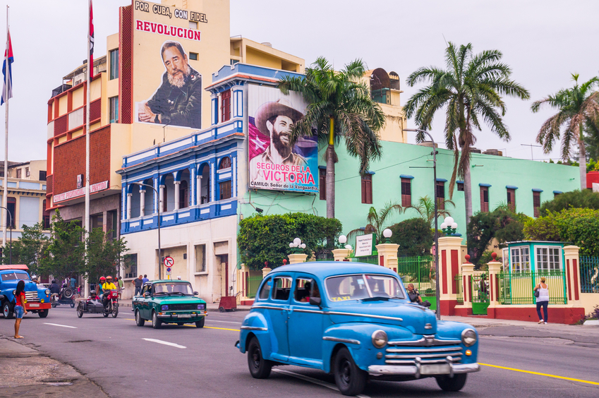 Street with oldtimers and propaganda in Santiago de Cuba